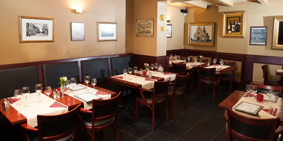 Zaal met houten tafels en ingelijste foto’s